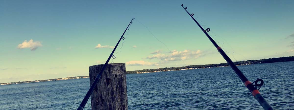Fishing rods on pier in sunset